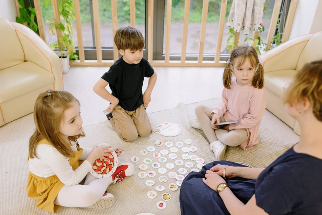 Group of children playing educational games indoors with a teacher.