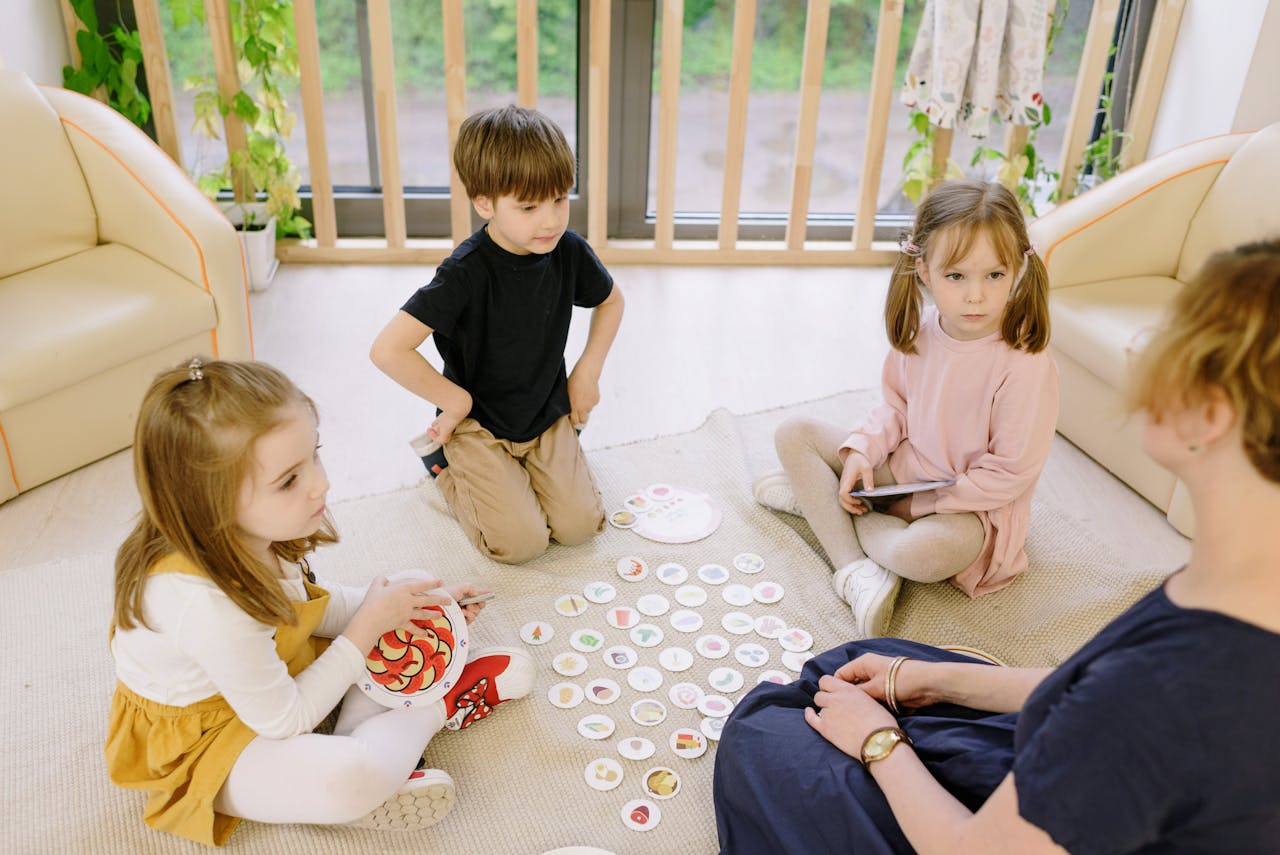Group of children playing educational games indoors with a teacher.